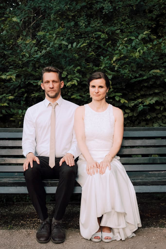 bride and groom sitting on a bench in the garden of the Teehaus Berlin