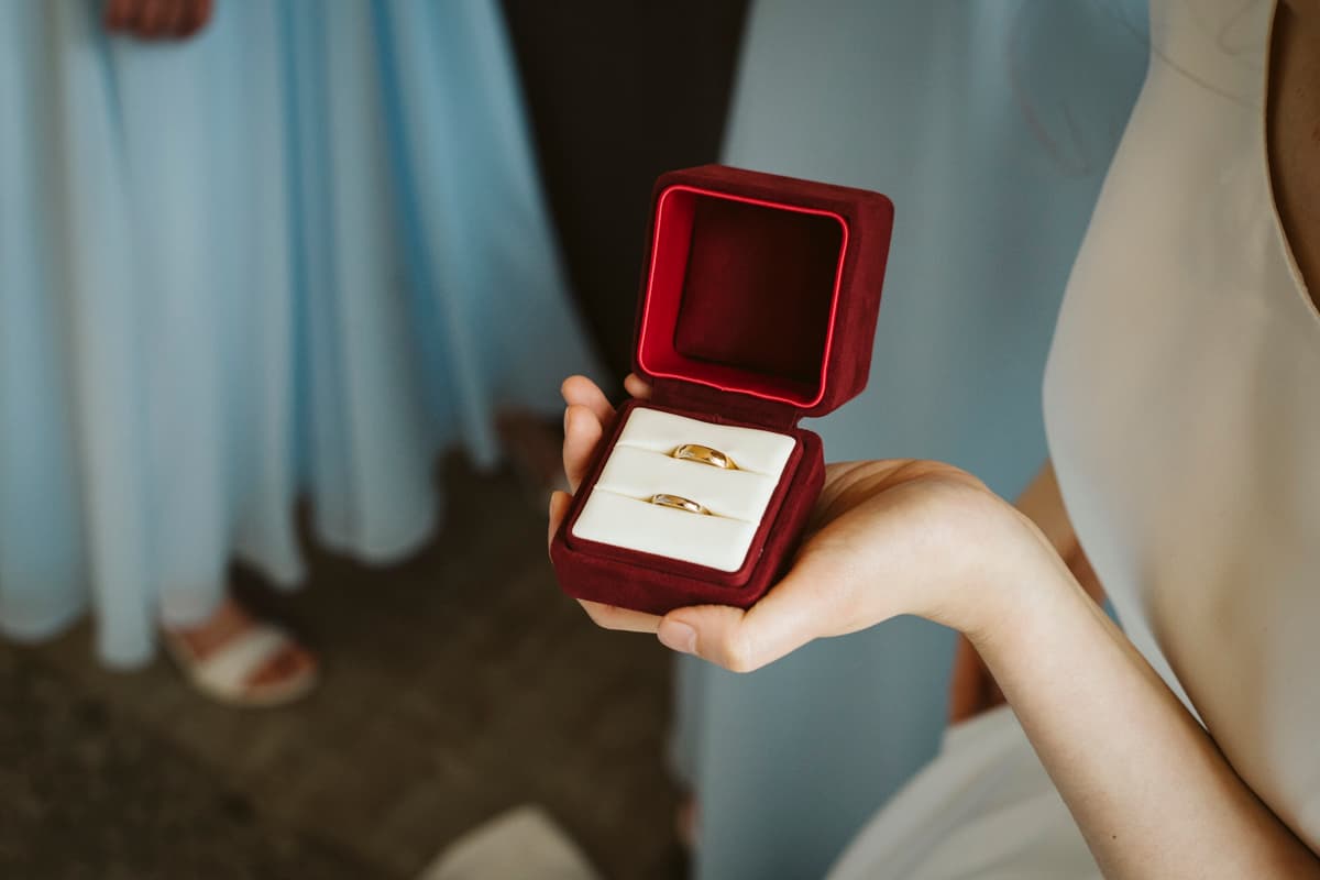 Bride shows golden wedding rings before the wedding celebration at Gästehaus Blumenfisch Berlin